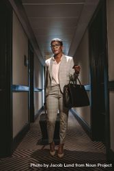 Businesswoman walking in hotel corridor with luggage 5pO9N0