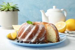 Cake with powder sugar and blueberry on blank background, space for text