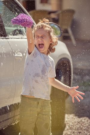 Cheerful boy with rag on sunny day
