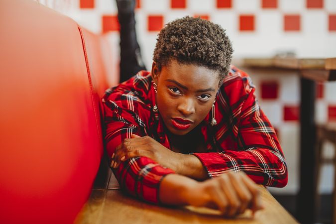 Gorgeous stylish Black woman lying on seats in cafe