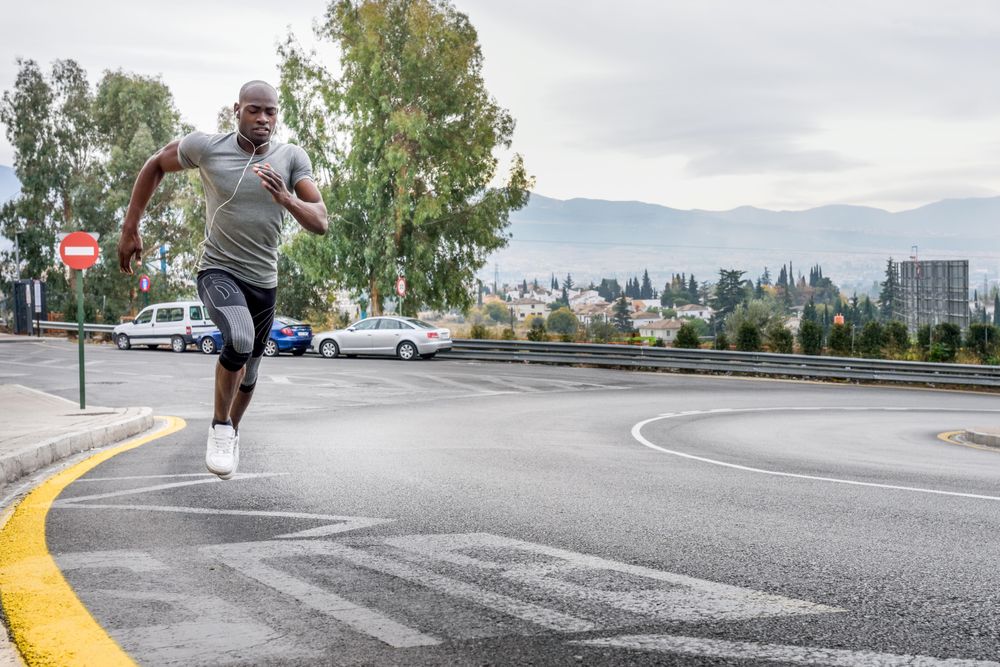Healthy male jogging on city street