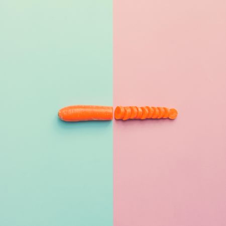Carrot cut in half on pink blue background