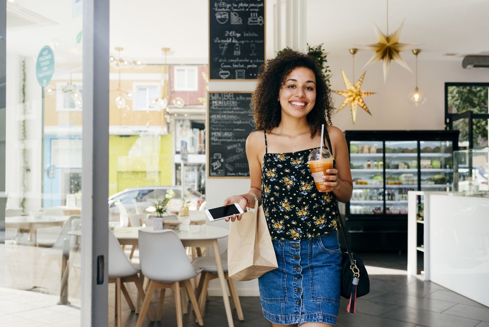 Cheerful hispanic woman leaving restaurant