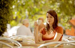 Adult female having tea in summer cafe