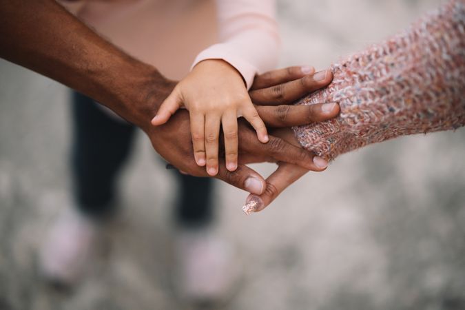 Hands of multiracial family putting together