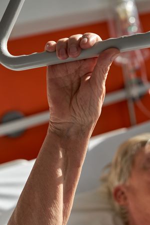 Crop anonymous woman holding handle while lying on medic