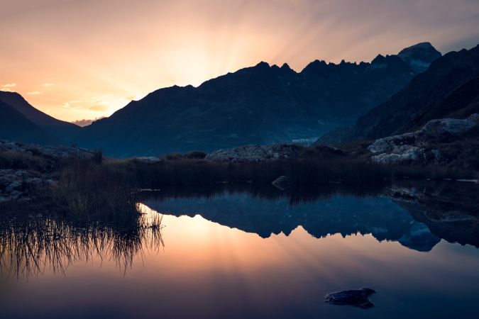 Calm lake in sunset light surrounded by mountains