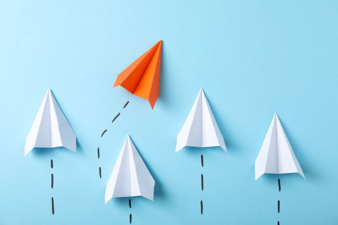 Paper airplanes on blue background, space for text