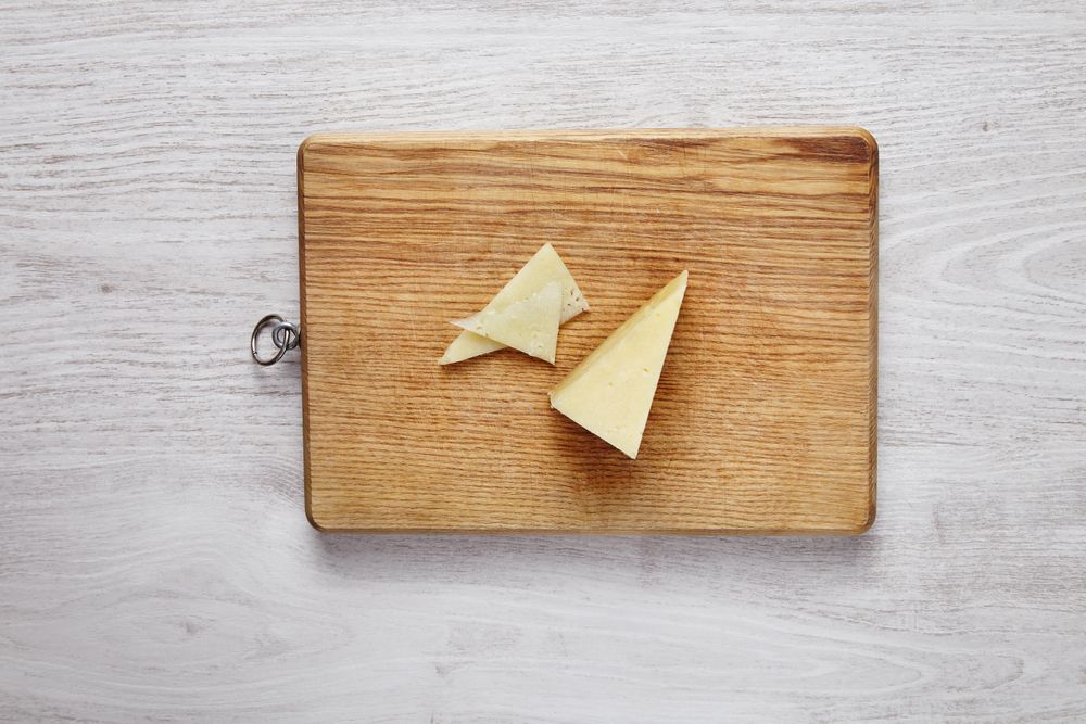 Chunk of Parmesan cheese on cutting board