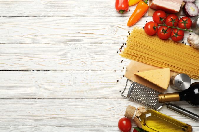 Composition with pasta and ingredients for cooking on wooden background, top view