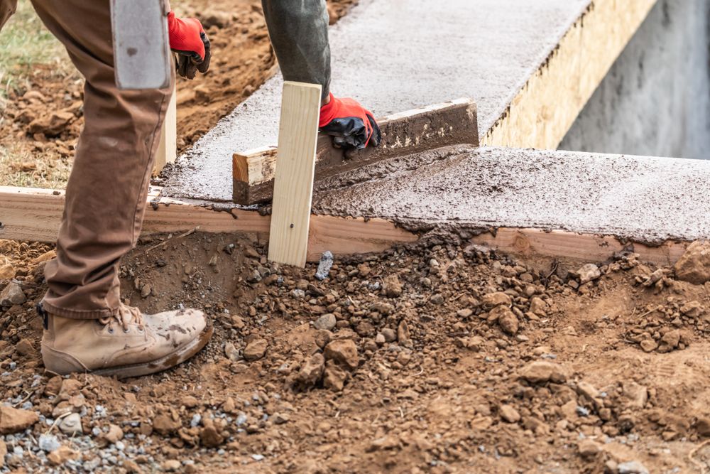 Construction Worker Leveling Wet Cement Into Wood Framing