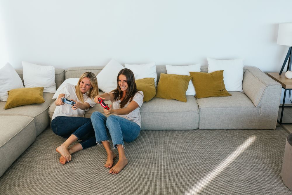 Cheerful women playing videogame on couch