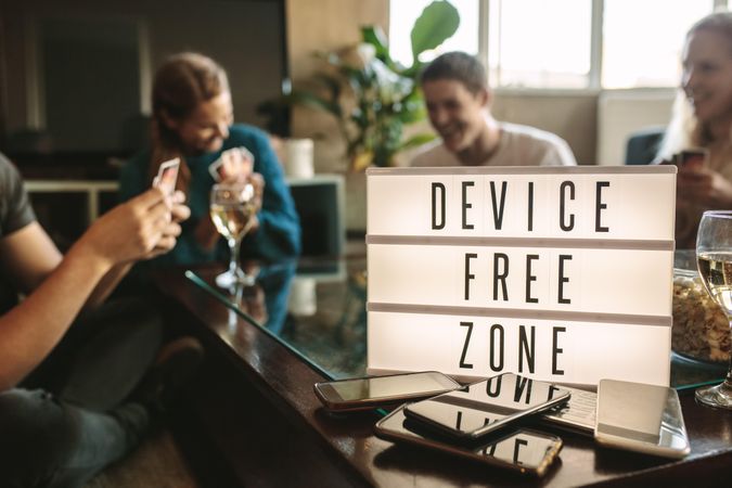 Mobile phones on table with device free zone sign