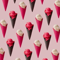 Pattern of vanilla and strawberry ice cream in waffle cones on pink background