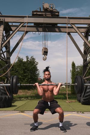 Black guy with barbell in outdoor gym