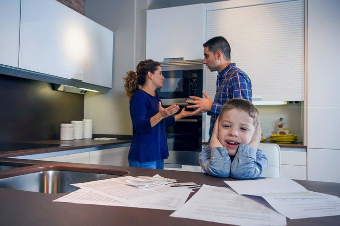 Man and woman having frustrating discussion in front of their son