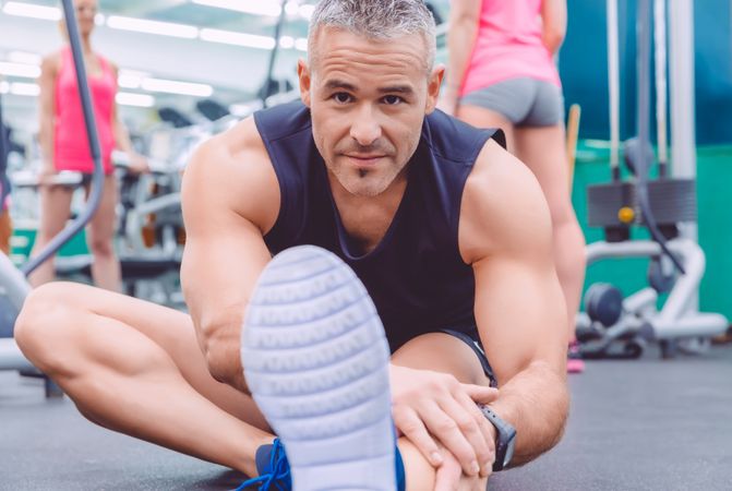 Male tying shoes in gym