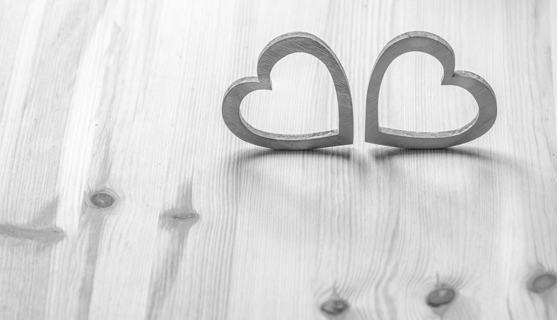 Two gray hearts on wooden table