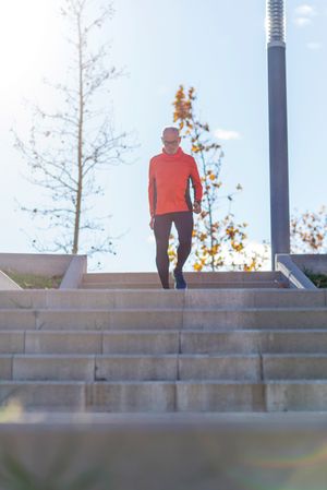 Older healthy male walking down stairs in park outside
