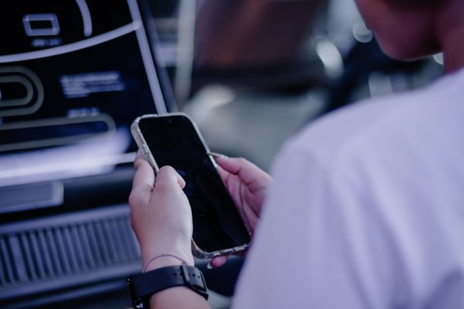 Person interacting with digital display screen via mobile technology