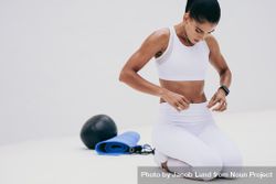 Athletic woman observing her abdomen while doing fitness training 0JVZv0