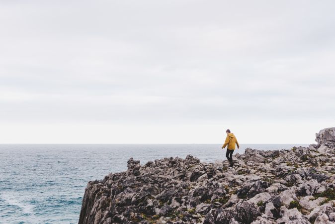Traveler in solitude walking on rocky shore