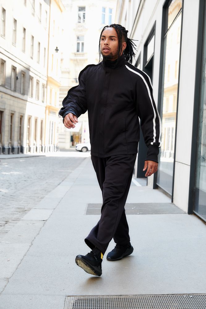 Black braided male walking down street