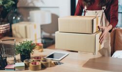 Woman working from home with boxes for shipment