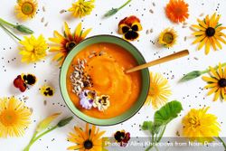 Top view of pumpkin soup with flowers on the table 5QAlg5