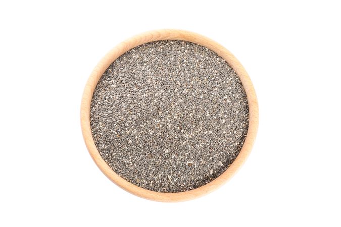 Chia seeds in wooden bowl isolated on studio background