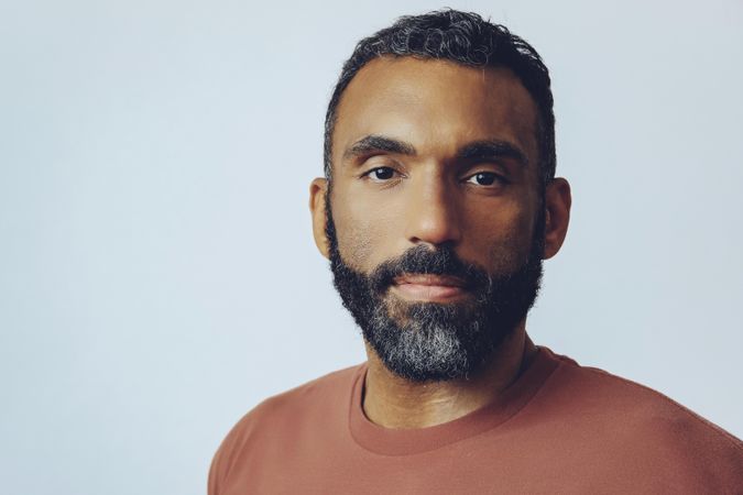 Head shot of serious Black male in grey studio, copy space