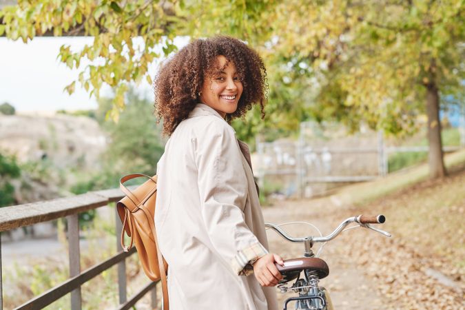 Smiling Black Latina woman with retro bike in autumn day