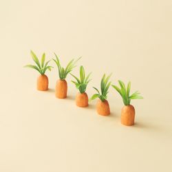 Row of carrots on pastel yellow background