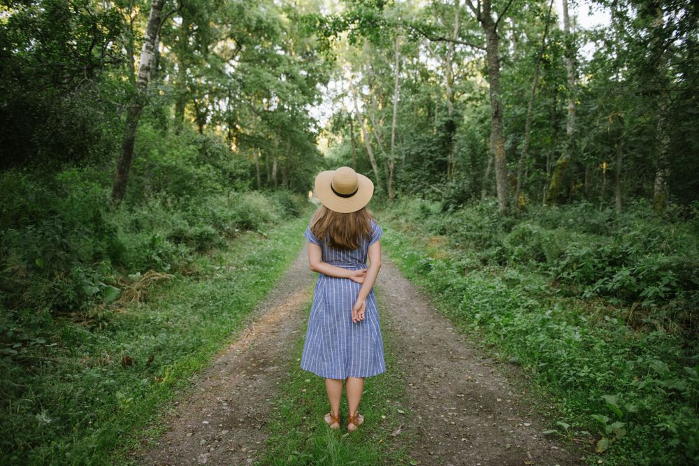 Young woman standing among pine trees