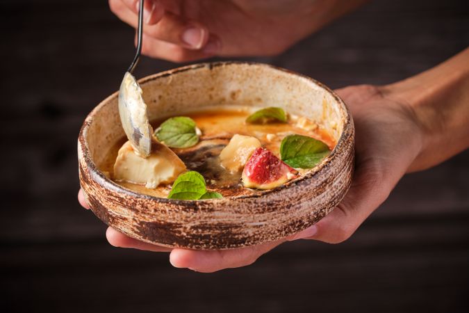 Hand holding bowl of delicate food