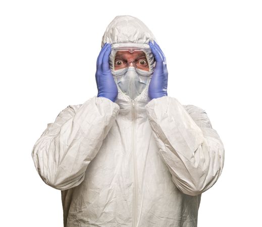 Man Holding Head With Hands Wearing HAZMAT Protective Clothing Isolated On A Plain Background.