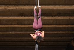 Slim woman doing aerial yoga in city