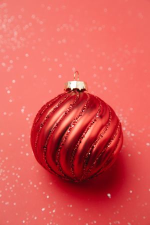 Red and silver bauble on pink textile