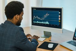 Black male trader typing on keyboard