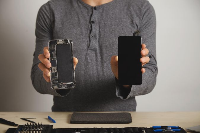 Man holding up a disassembled smart phone