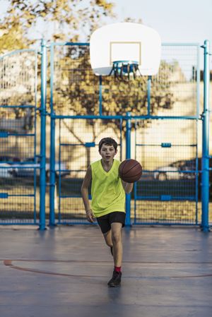 Active teen enjoying outdoor game with orange ball