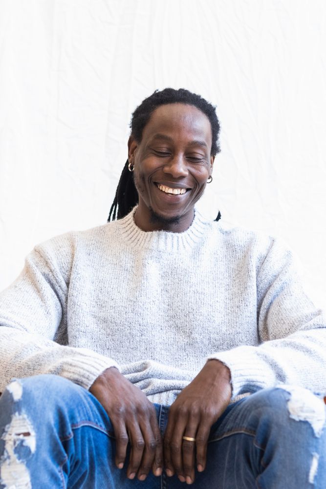 Black man with dreadlocks smiling widely