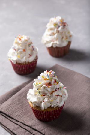 Tasty party cupcakes on the table. Cupcakes with whipped cream.