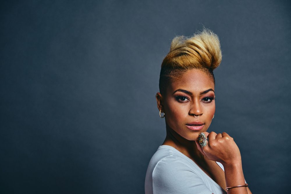 Portrait of proud Black woman with short blonde hair and hand to her chin