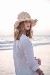 Woman in light white dress on wavy beach