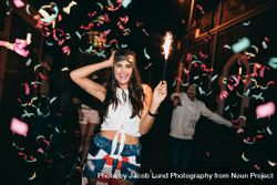 Happy young woman partying with her friends outdoors at night 4OxAJb