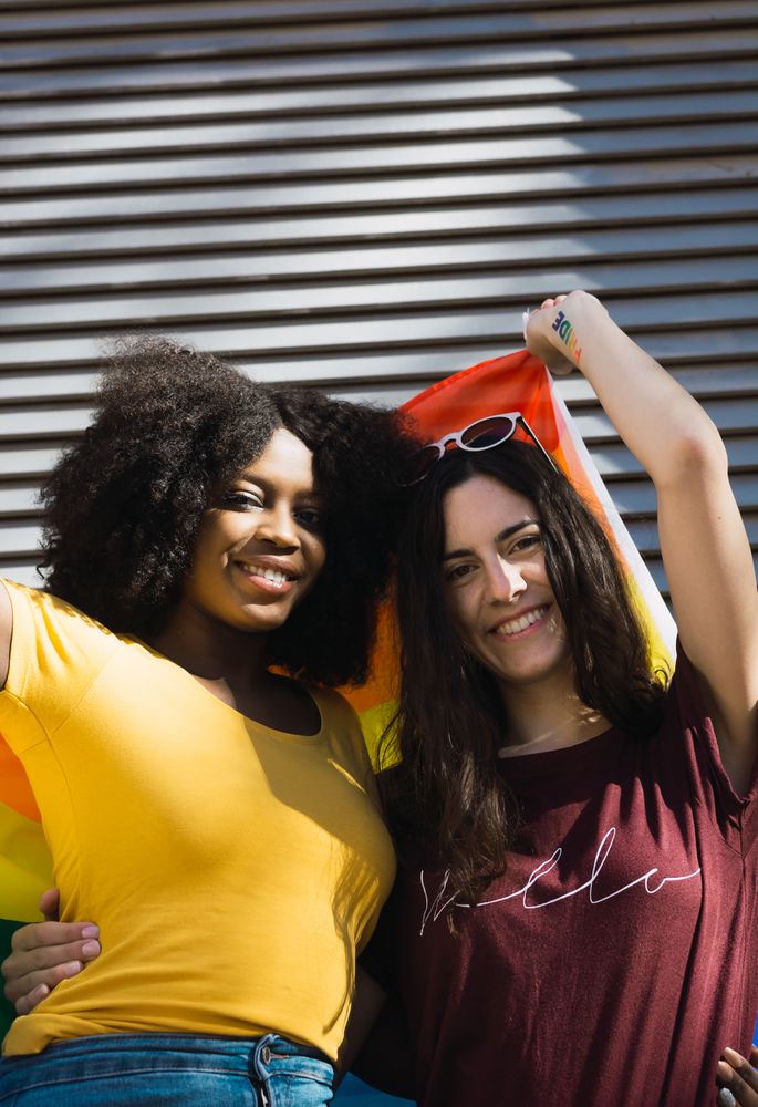 Lesbian couple wrapped in LGBT flag
