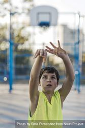 Teenage playing basketball on an outdoors court 5o7P85