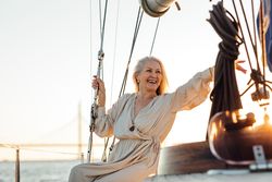 Joyful older woman with long gray hair on a boat