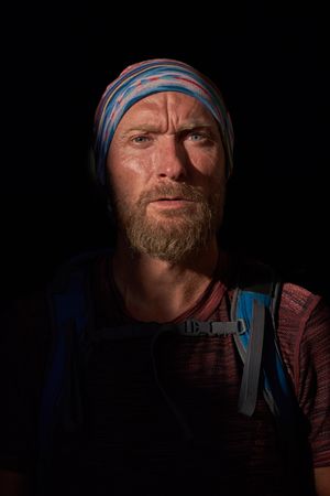 Serious male hiker in dark room